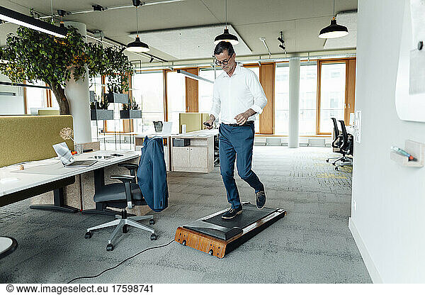 Working man running on treadmill at office