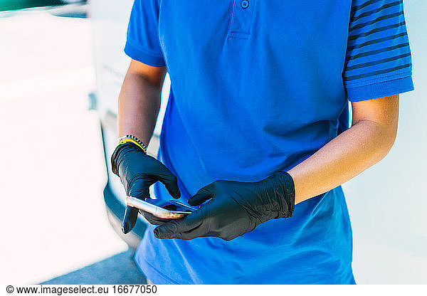 Working with the mobile with black latex gloves in the center of Madri