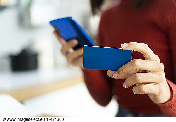 Working woman holding credit card and smart phone