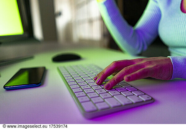 Working woman typing on keyboard on desk at home office