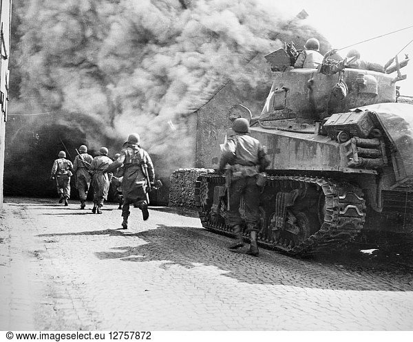 WORLD WAR II: U.S. TROOPS. American soldiers run through a smoke-filled street in Warnberg,  Germany,  April 1945.