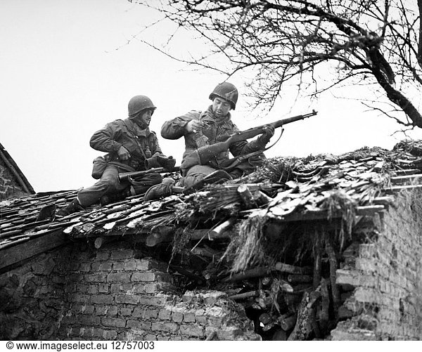 WORLD WAR II: BELGIUM. American rifleman on a rooftop in Beffe  Belgium  snipe German snipers. Photographed 7 January 1945.