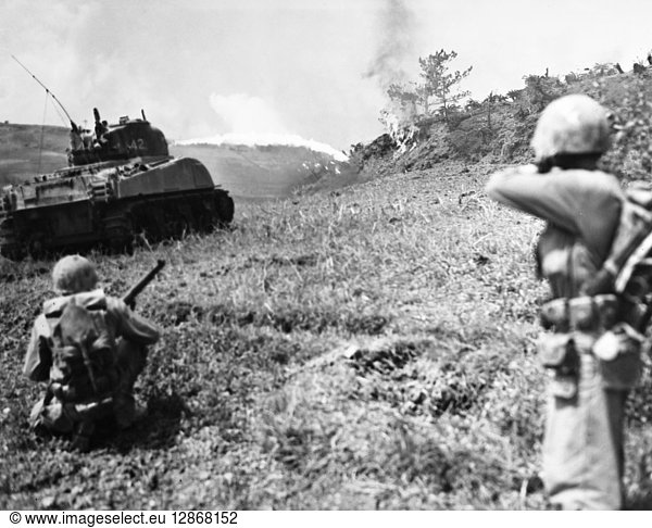 WORLD WAR II: OKINAWA. Flame-throwing tank and U.S. Marines rifleman moving up to the front lines during the Battle of Okinawa  11 May 1945.