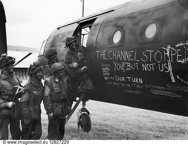 WORLD WAR II: WAR PAINT. Camouflaged British soldiers admire the slogans painted on the side of an airplane  before the invasion of Normandy  June 1944.