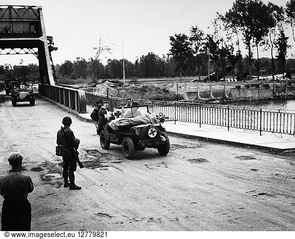 WORLD WAR II: WOUNDED. A Red Cross jeep carrying wounded soldiers drives across the Caen Canal bridge in Normandy  France  during the Allied invasion  June 1944. Crashed gliders can be seen in the background.