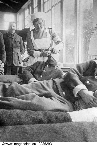 WWI: HOSPITAL  c1915. A nurse bandaging the head of a soldier at the Canadian hospital in the Hotel du Golf at Le Touquet  France. Photograph  c1914.