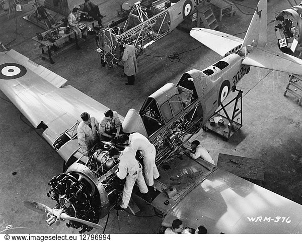 WWII: AIRPLANE FACTORY. Workers assembling airplanes at a factory in Canada during World War II. Photograph  1941.