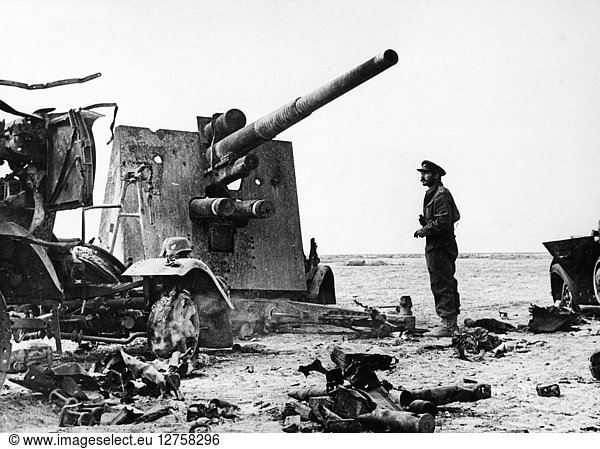 WWII: ANTI-AIRCRAFT GUN. An eighth Army officer beside a destroyed German 88 mm gun designed for anti-aircraft and long range shelling. Photographed near Tobruk  Libya  c1943.