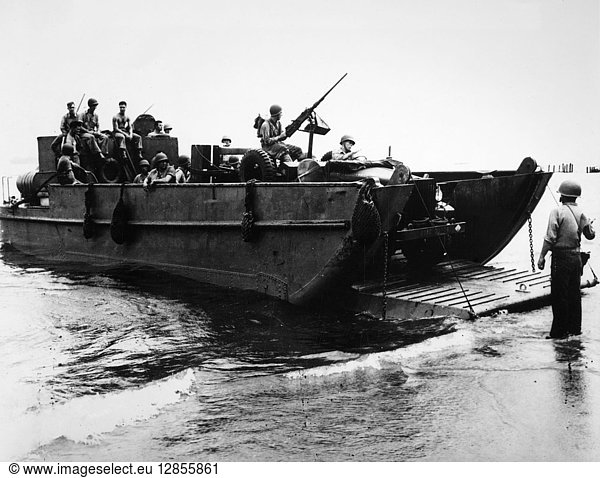 WWII: GUADALCANAL  c1942. An American landing craft dropping its ramp on the beach at Guadalcanal in the Solomon Islands  as the U.S. Marine reconnaissance car unloads. Photograph  c1942.