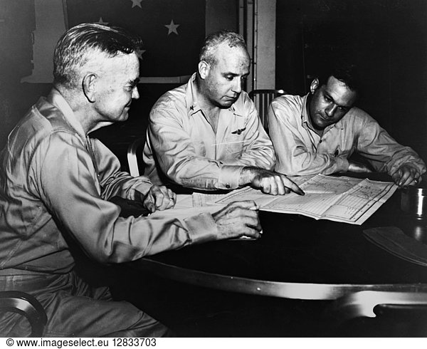 WWII: PHILIPPINE STRATEGY. American Naval Admiral William Halsey (left) with two staff members  planning strategy for the Philippine campaign  on board a naval carrier. Photograph  c1942.