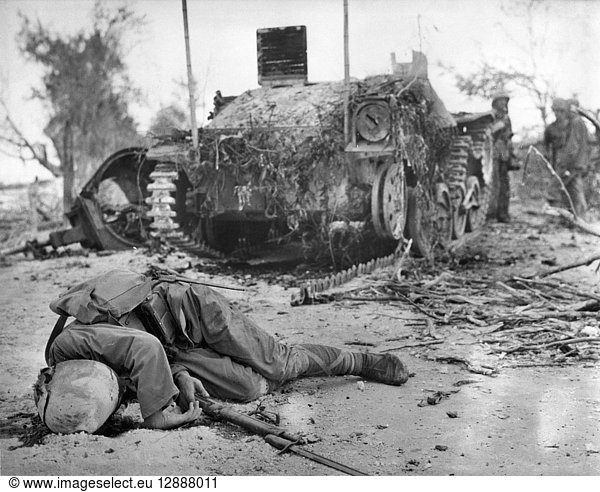 WWII: SAIPAN  1944. A dead Japanese soldier and a Japanese tank disabled by U.S. Marines on Saipan  July 1944.