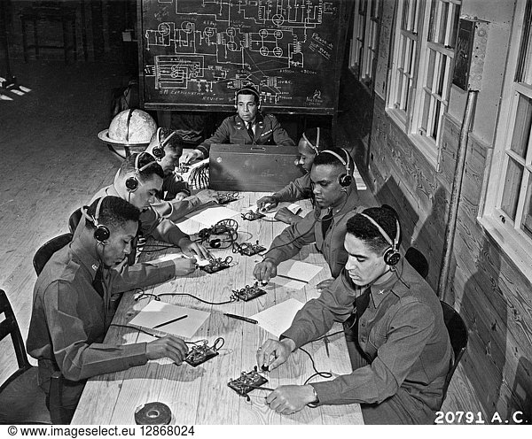 WWII: TRAINING  1942. Men in training for the Air Corps at the Tuskegee Institute in Tuskegee  Alabama  learning Morse code from Captain Roy F. Morse. Troops include James Knighton  Lee Rayford  C.H. Flowers  Jr.  George Levi Knox  Sherman W. White  Jr.  and Mac Ross. Photograph  January 1942.