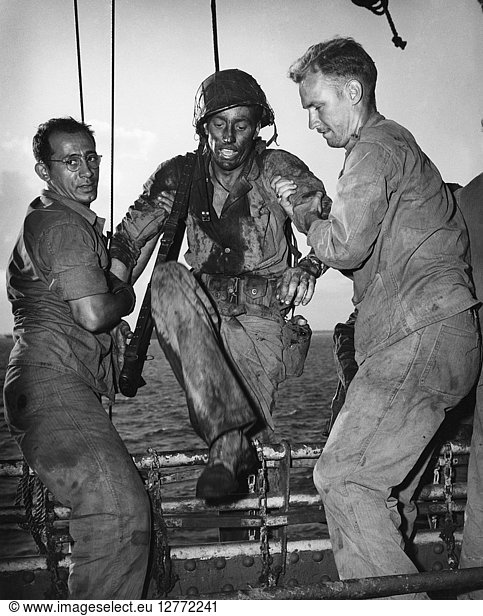 WWII: TROOPS  c1944. U.S. Coast Guardsmen helping a Marine onto an assault transport after a battle on Eniwetok Atoll in the Marshall Islands. Photograph  c1944.