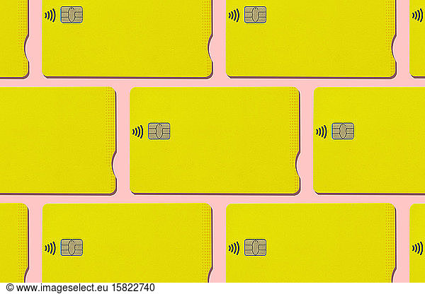 Yellow contactless credit cards pattern on pink background