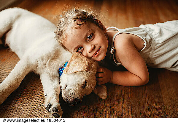 yellow Labrador lab puppy snuggling with little girl