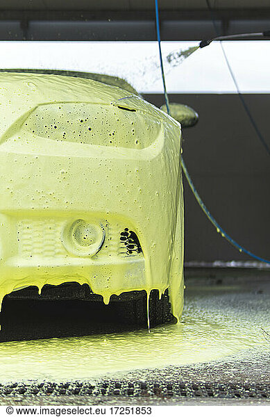 Yellow soap sud on car at garage