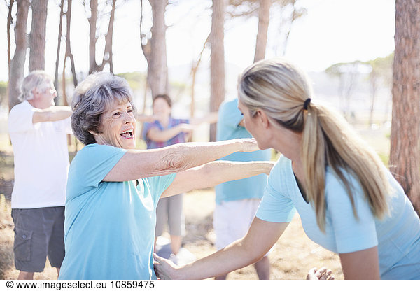 Yogalehrerin führt Seniorin im Park
