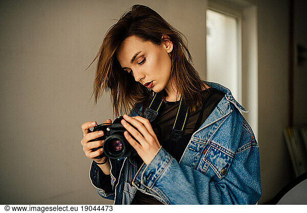 Youg female photographer holding camera.