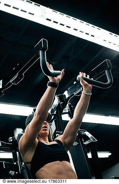 young adult woman working out in gym wearing black sports bra