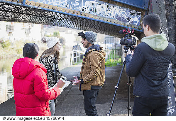 Young adults vlogging under urban bridge