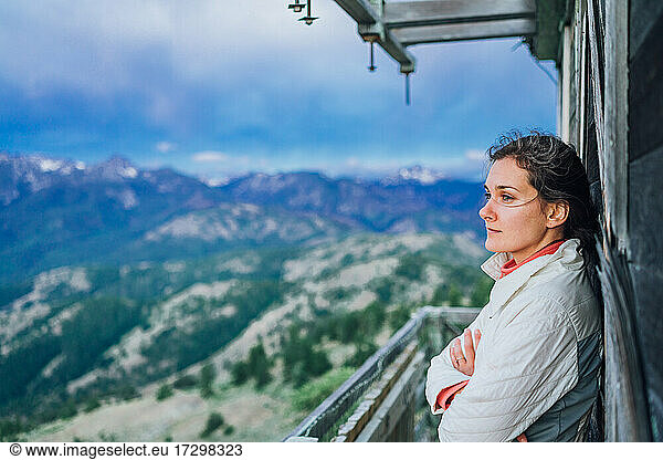 Young adventurer watching sunrise on top of fire lookout in Washington