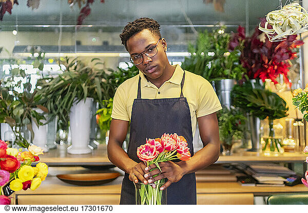 young african entrepreneur looking at the flowers of his business