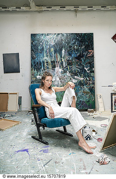 Young artist sitting in her studio