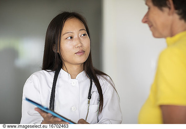 young asia female doctor woman and patient with report in a practice