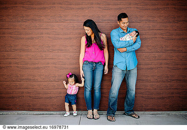 Young Asian-American family with toddler girl and newborn baby