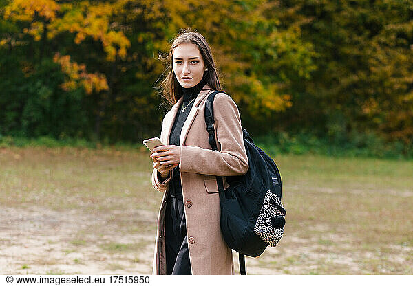 Young asian brunette girl holding smartphone outdoor