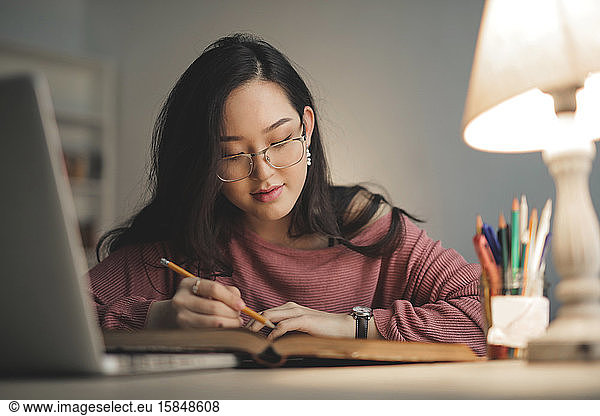 young asian woman studying at home