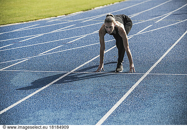 Young athlete at starting line of track