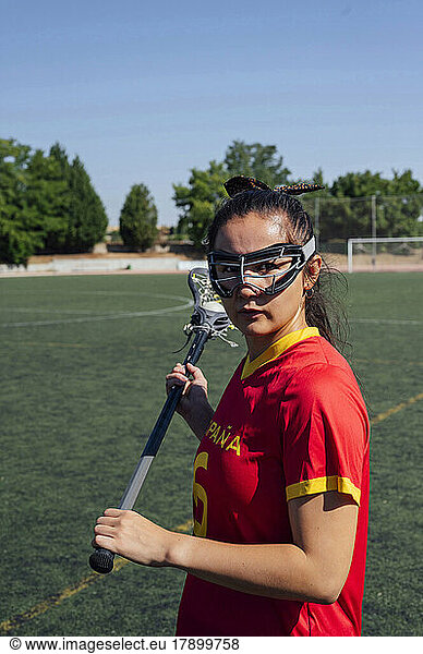 Young athlete with lacrosse eyewear playing on sports field