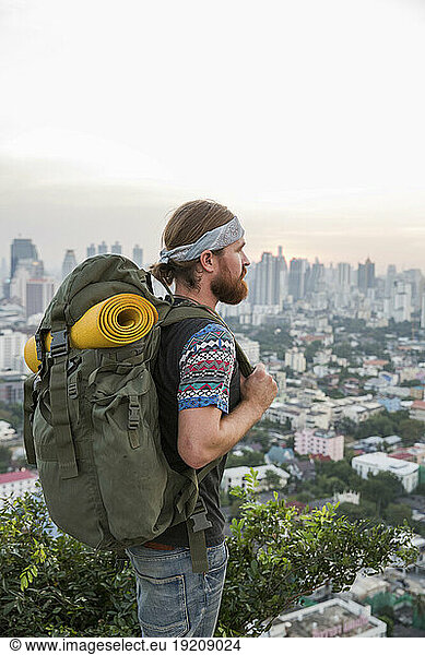 Young backpacker looking at city view