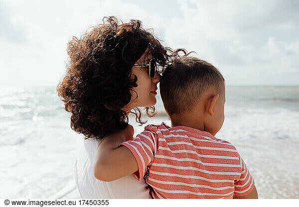 Young beautiful mommy ith her baby son on the beach