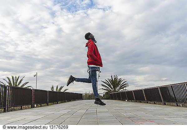 Young black man standing outdoors jumping for joy