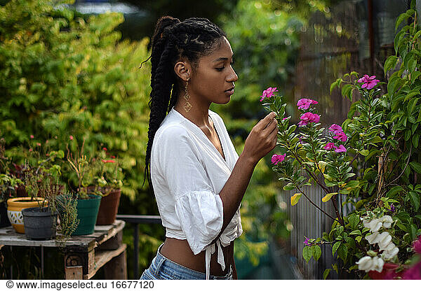 Young black woman smelling flowers