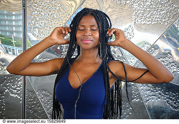young black woman with very long braids and very attractive and sensual enjoying barcelona in summer and doing model with mobile  glasses and camera  technology concept.Barcelona  Spain