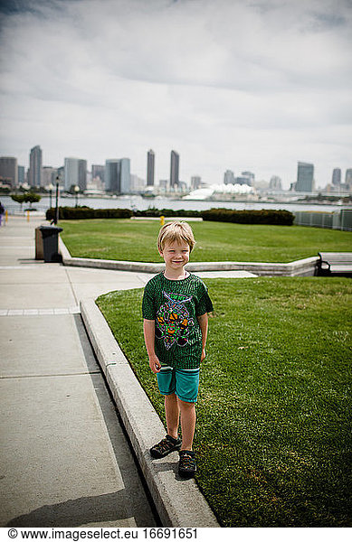 Young Blond Boy Smiling with San Diego Skyline in Background