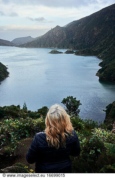 Young blonde woman observing the lake 'do fogo' of Sao Miguel  Azores
