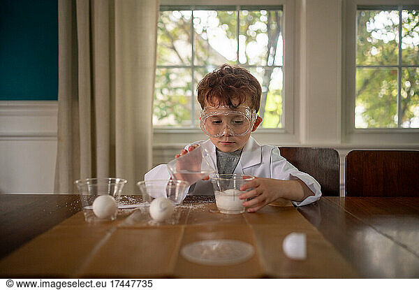 Young boy conducting a science experiment dressed in lab coat