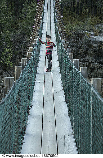Young Boy Crosses Suspension Bridge