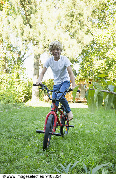 Young boy cycling in the garden
