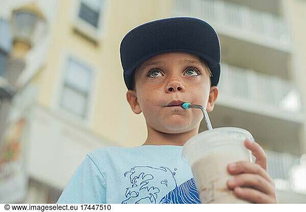 young boy drinking a milkshake