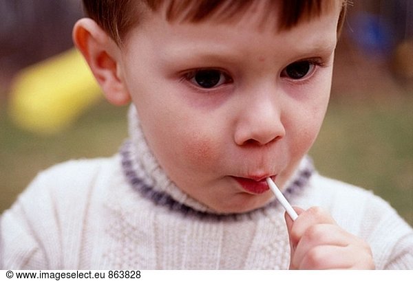 Young boy eating lollipop