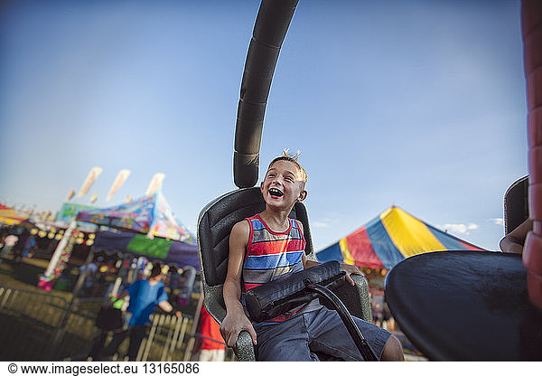 Young boy enjoying fairground ride