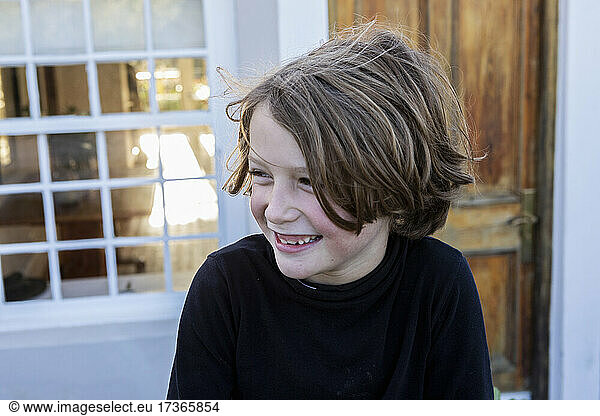 Young boy laughing  looking sideways  head and shoulders