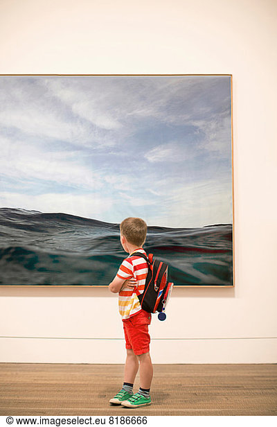 Young boy looking at picture in gallery