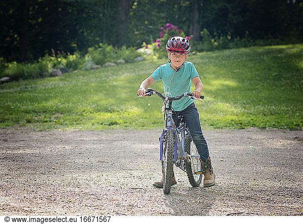Young Boy on Bike in Driveway