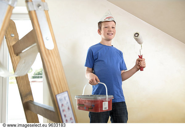 Young boy painting decorating room happy